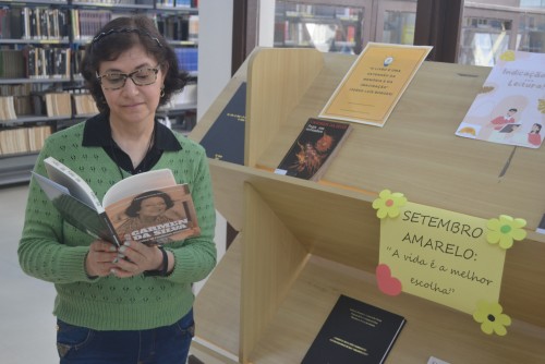 Bibliotecária Simone Przybylski com os livros da autora rio-grandina Carmen da Silva, em exposição na Biblioteca Central da FURG